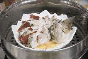 將鱸魚成花狀擺好，將火腿切片放入各縫隙中，放入鍋中隔水蒸12分鐘拿出，撒上蔥花即可。