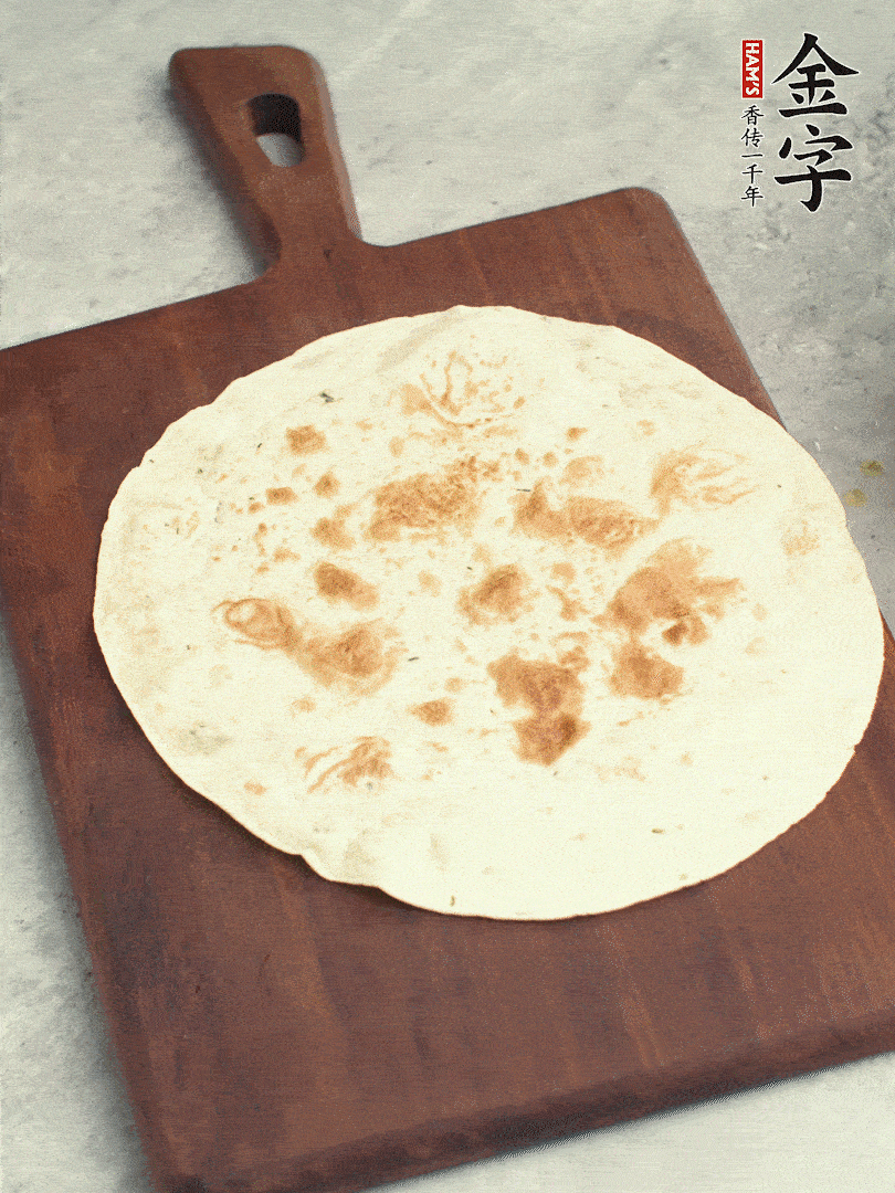 食材依次鋪在卷餅皮上，卷起來。