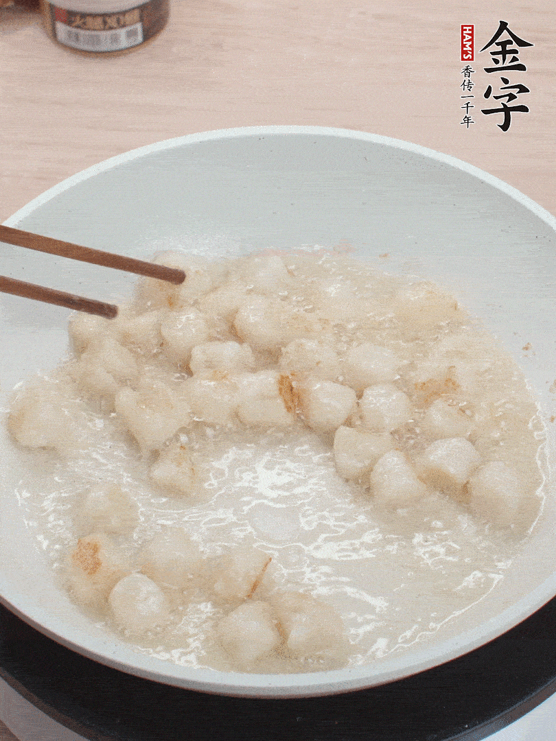 油溫4成熱，鮮貝蘸干淀粉下鍋煎，一面微黃后翻面。