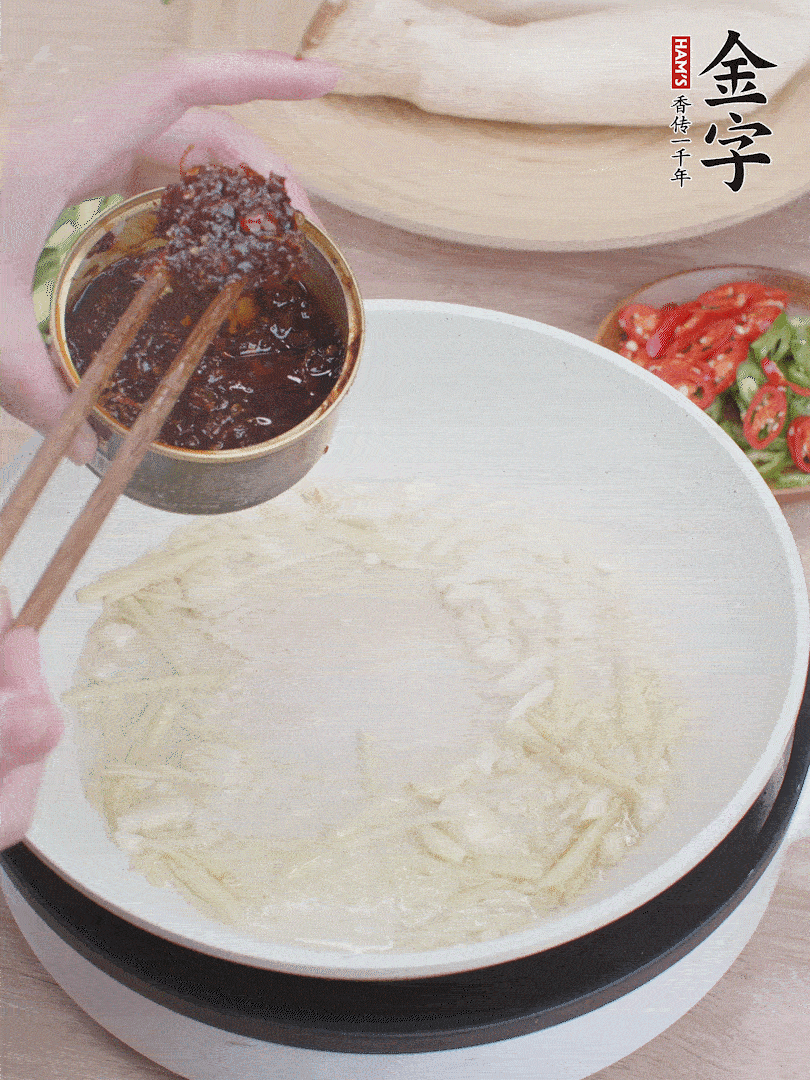 起鍋熱油，姜蒜、金字火腿干貝醬煸香。