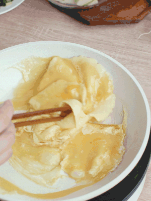 油6成熱時，下雞蛋液，邊緣凝固時翻拌成塊狀。