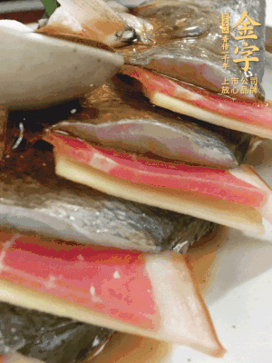 魚肚中塞蔥結(jié)、火腿片，魚身上碼放姜片、火腿片，倒入混合的料汁。