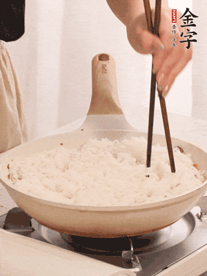 把瀝干水分的米飯均勻鋪在上面，筷子戳幾個洞，以便透氣，轉(zhuǎn)小火蓋上蓋子燜至水分收干，大概10分鐘。