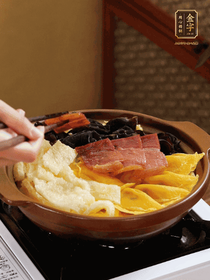 砂鍋底部鋪上娃娃菜，依次擺上肉皮、蛋餃、黑木耳、火腿